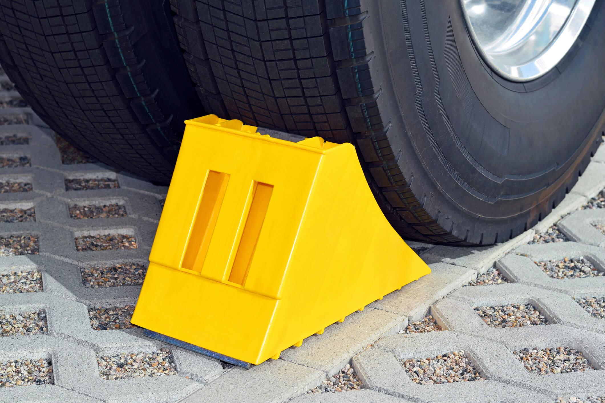 A yellow wheel chock placed against a tire