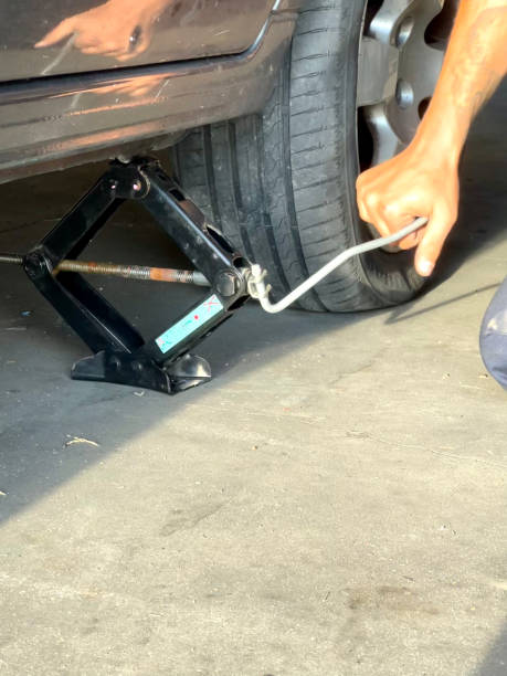 A scissor jack lifting a vehicle — not allowed